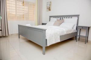 Zanube Apartments في ندولا: غرفة نوم مع سرير كبير مع منضدة وسرير six sidx