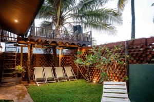 a group of chairs sitting on the grass near a building at Sunsei Beach Negombo in Negombo