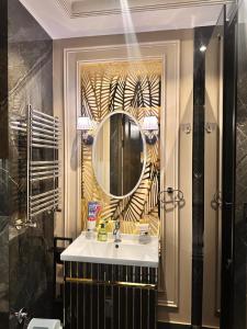 een badkamer met een wastafel en een spiegel bij Toshkent city apartments in Tasjkent +92 foto's