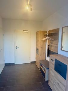 a kitchen with a white door and a tile floor at Ferienwohnung Auszeit am Waldrand in Olpe