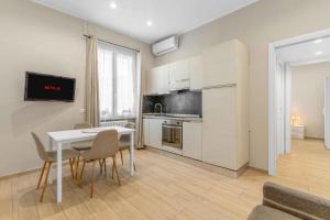 una cucina e una sala da pranzo con tavolo e sedie di Bovisa Appartamento Wi-Fi Ultra Rapido e AC a Milano