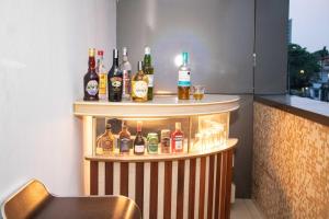 a bar with a bunch of bottles of alcohol at A2G Apartments in Douala