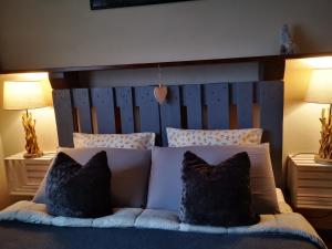 Bett mit einem Kopfteil aus Holz und 2 Kissen in der Unterkunft La maison de Carmen in Aosta