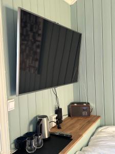 a room with a counter with a microwave and a tv at Anekset in Sandefjord +10 photos