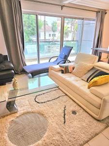 a living room with a couch and a glass table at A2G Apartments in Douala