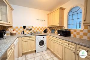a kitchen with a washing machine and a sink at Central Woking 2 Bedroom 2 Bath Modern Apartment with Parking in Woking +5 photos