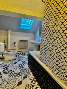 a bathroom with a tub and a toilet and a sink at Studio Cosy & Lumineux dans le centre-ville in Brive-la-Gaillarde