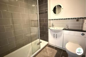 a bathroom with a toilet and a sink and a shower at Central Woking 2 Bedroom 2 Bath Modern Apartment with Parking in Woking