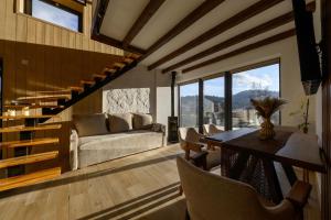 a living room with a couch and a table at Domivka котедж із чаном-джакузі, каміном і кіно-зоною у Cлавську in Slavske