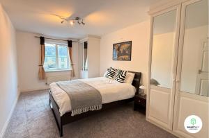 a bedroom with a bed and a window at Central Woking 2 Bedroom 2 Bath Modern Apartment with Parking in Woking