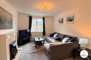 a living room with a couch and a tv at Central Woking 2 Bedroom 2 Bath Modern Apartment with Parking in Woking