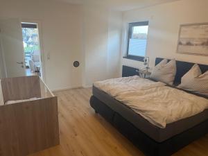 奥尔珀Ferienwohnung Auszeit am Waldrand的带床和木地板的卧室