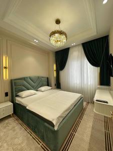Un dormitorio con una cama grande y una lámpara de araña. en 5 Star Apartment, en Tashkent