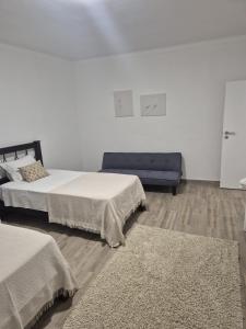 una camera con due letti e un divano blu di Casa Branco a Borba