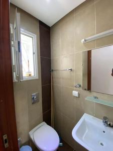 a bathroom with a toilet and a sink at Rim Apartment , Beachfront in Ḩammām al Ghazzāz +22 photos