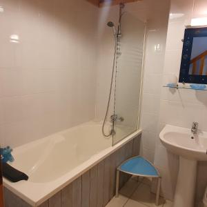 a bathroom with a bath tub and a sink at Moros in Melgven