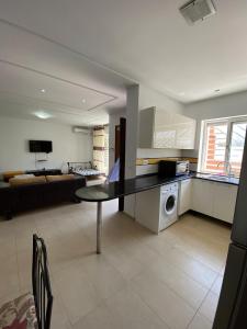 a kitchen with a table and a living room at Rim Apartment , Beachfront in Ḩammām al Ghazzāz