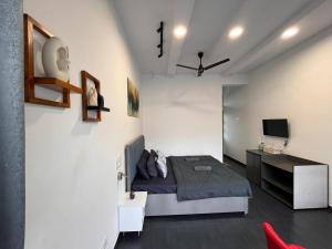 a bedroom with a bed and a desk and a tv at Casa Oceanus - Pool View Room - Ganpatipule in Nevra