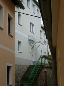 eine Treppe, die zu einem weißen Gebäude mit grünem Geländer führt in der Unterkunft Ferienwohnung Seidel in Bad Schandau