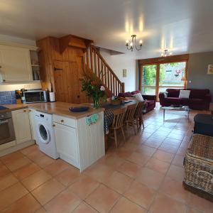 a kitchen and living room with a table and a dishwasher at Moros in Melgven
