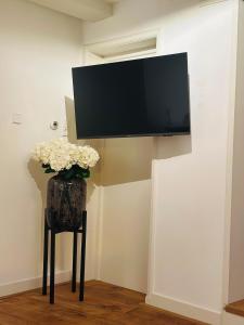 a tv on a wall with a vase of flowers at Boutique LaBeau in Amsterdam