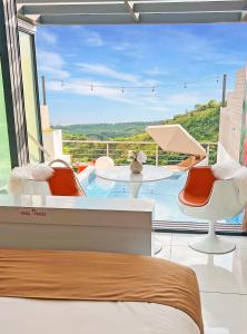 a bedroom with a large window with a table and chairs at The View Luxe Boutique Hotel 