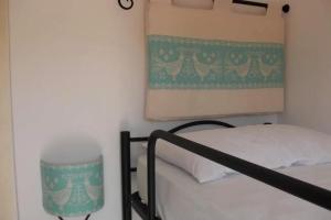 Vignola MareAffittaSardegna - Domo Vignola的卧室里有一张床，墙上挂着一幅画