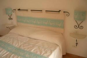 Vignola MareAffittaSardegna - Domo Vignola的一间卧室配有一张白色床和绿色床头板