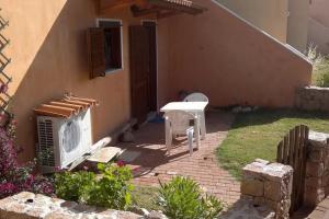 Vignola MareAffittaSardegna - Domo Vignola的房屋前设有带桌椅的天井。