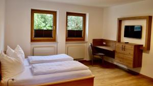 a bedroom with two beds and a desk and a television at Kurapotheke in Bad Hofgastein