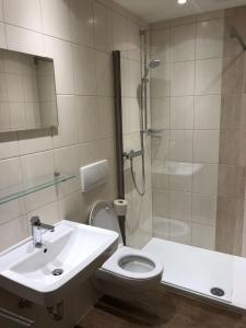 a bathroom with a sink and a toilet and a shower at Kurapotheke in Bad Hofgastein
