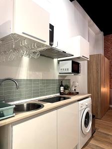 a kitchen with white cabinets and a sink and a dishwasher at Apartmento Ópalo in Seville