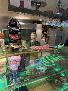 a man standing behind a counter in a bakery at Rosenli Gård in Tønsberg +3 photos