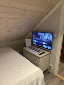 a bedroom with a bed and a flat screen tv at Rosenli Gård in Tønsberg