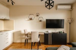 a kitchen with a table and a television on the wall at GALAKTIK centar in Apatin