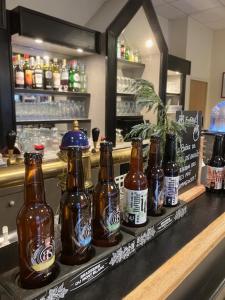 eine Reihe von Bierflaschen auf einer Bar in der Unterkunft The Originals City, Hôtel du Faucigny, Cluses Ouest in Scionzier