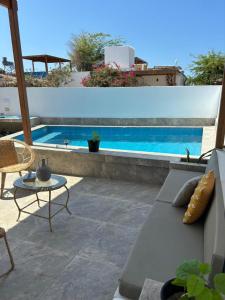 Casa Siena Vichayito a poco metros del mar في لوس أورغانوس: فناء مع أريكة وحمام سباحة