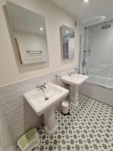 um banheiro com duas pias, um chuveiro e um espelho em The Shrubbery-Superb Modern home-6 beds-sleeps 11 em Topsham mais 38 fotografias