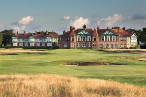 ein großes Gebäude auf einem Golfplatz mit einem Grün in der Unterkunft Fairhaven View Apartments - Lytham St Annes in Lytham St Annes