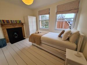 um quarto com uma cama com lareira e janelas em The Shrubbery-Superb Modern home-6 beds-sleeps 11 em Topsham