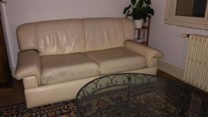 a leather couch in a living room with a table at Chambre avec sdb privative - Maison La Libéllule in Besançon