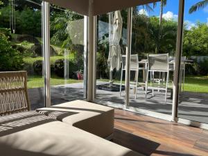 a room with a bed and a view of a patio at La Grippiere in Petit-Bourg