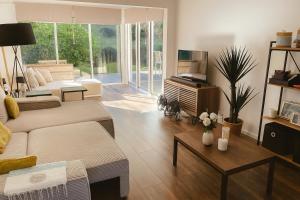 a living room with a couch and a tv at La Grippiere in Petit-Bourg