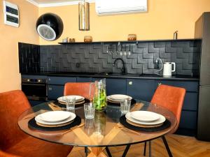 eine Küche mit einem Glastisch und orangefarbenen Stühlen in der Unterkunft Biała Mewa in Huta