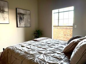 Un dormitorio con una cama y una ventana en The Luxe Loft Boho Chic, en Duluth