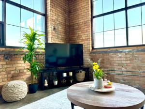 Una sala de estar con una mesa y un televisor. en The Luxe Loft Boho Chic, en Duluth