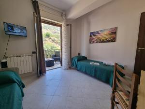 a bedroom with a green bed and a window at House Calamigna in Ventimiglia di Sicilia