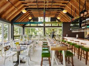 a dining room with tables and green chairs at Drake Devonshire and Motor Inn in Wellington
