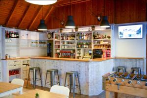 a bar with stools and a counter with bottles of alcohol at Camping Bedura Park in Era Bordeta