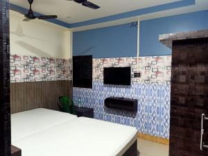 a room with two beds and a tv on a wall at Paribartan Hotel & Lodge in Farakka +21 photos